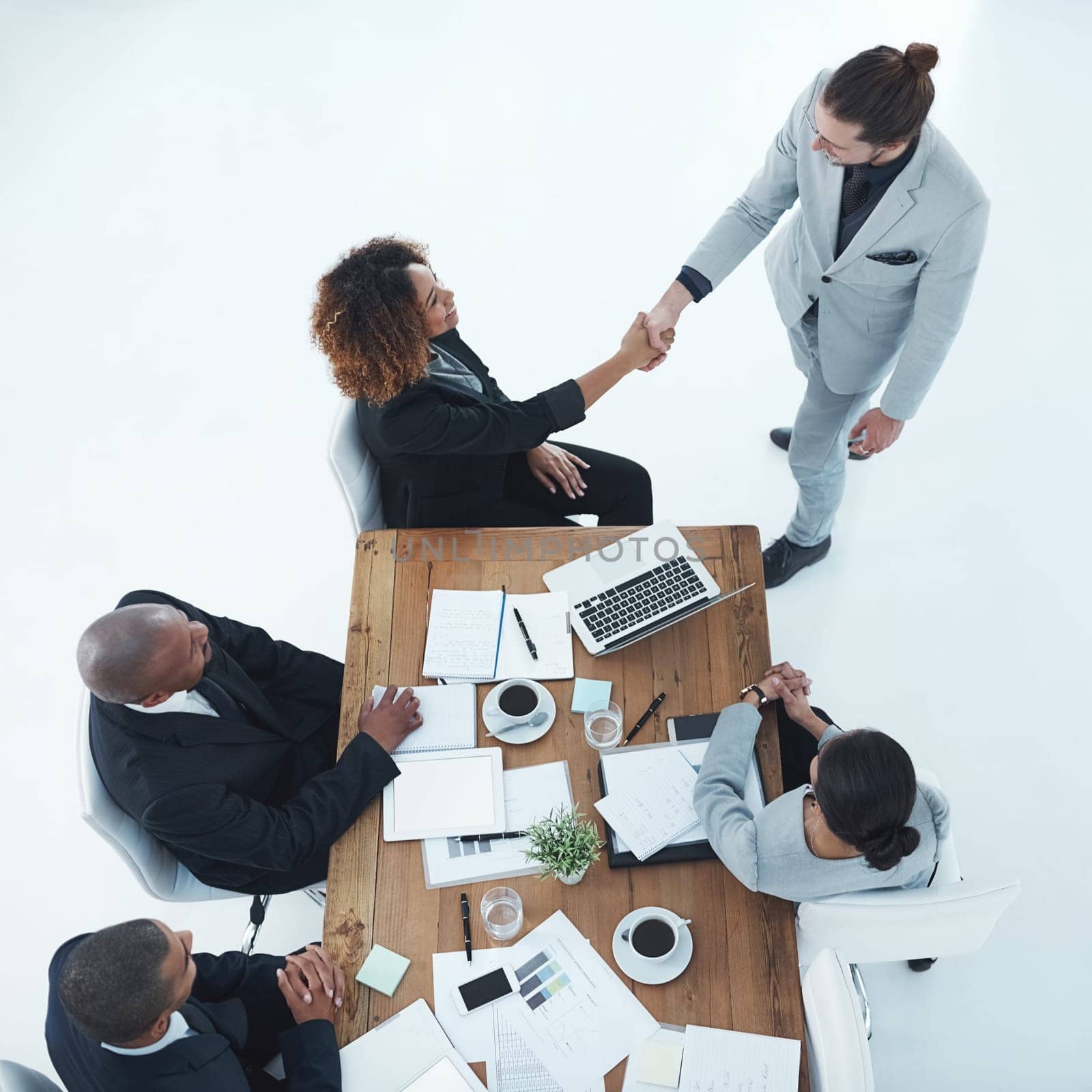 Welcome, youre just on time. two businesspeople shaking hands in a staff meeting