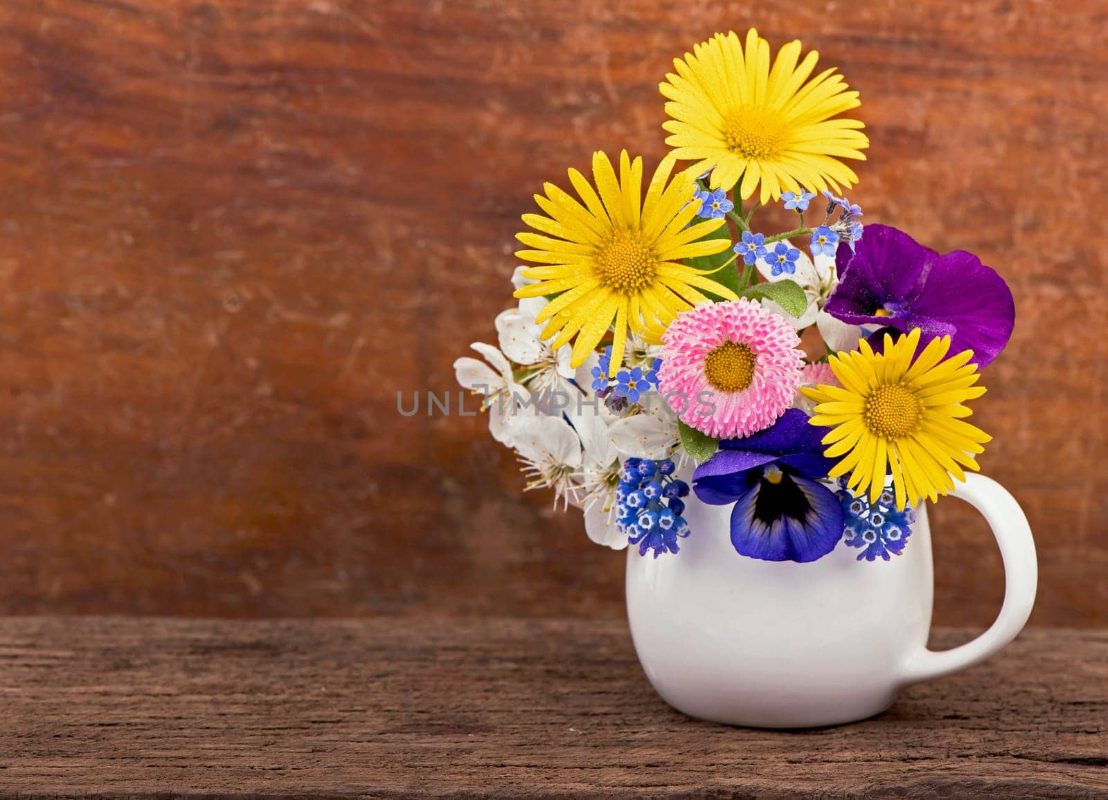 small spring bouquet. Bouquet of wild flowers in a small vase on a wooden table. Bouquet of daisies. Country style. by aprilphoto