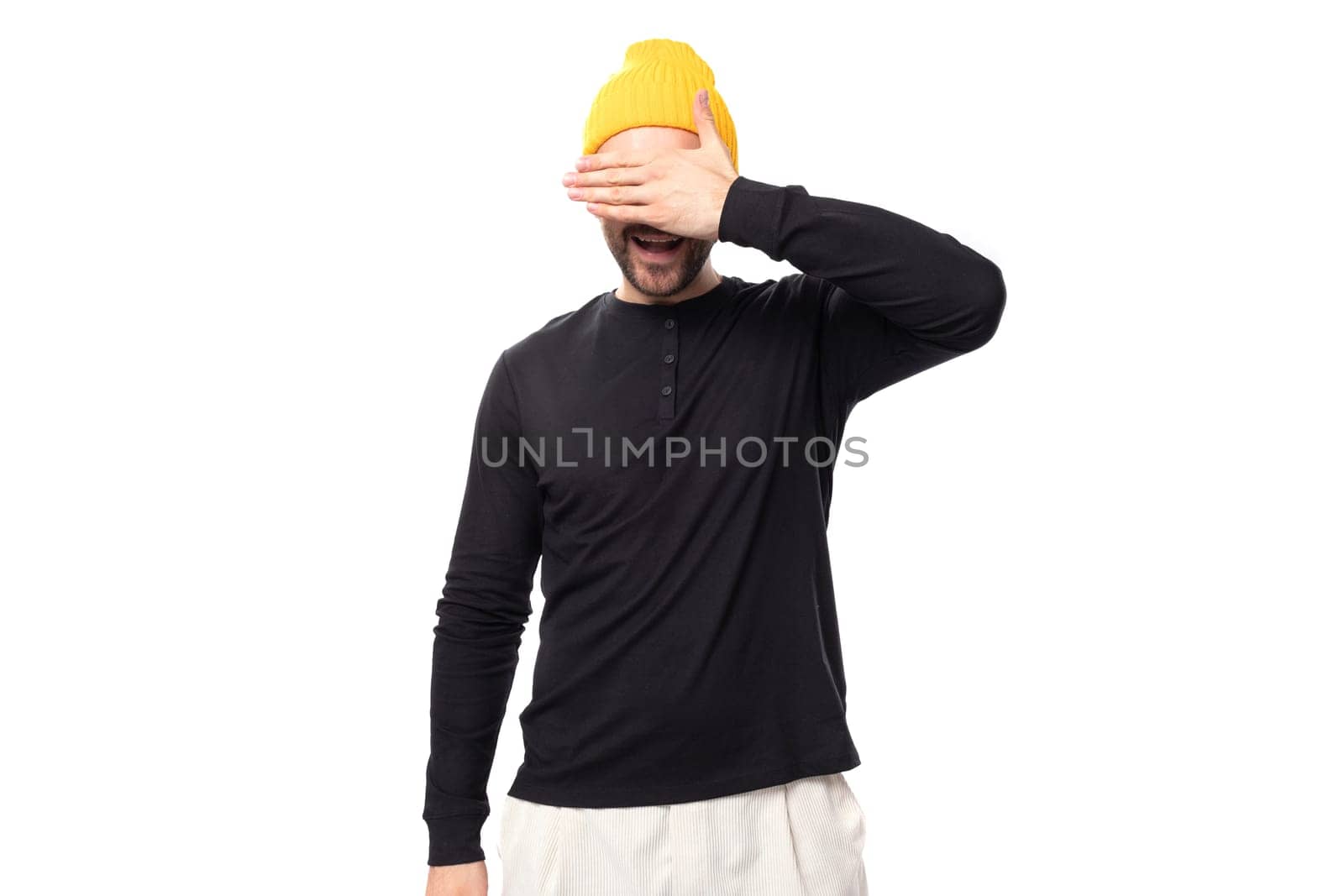 shy young 30 year old guy with a beard dressed in a black jacket and a yellow hat by TRMK