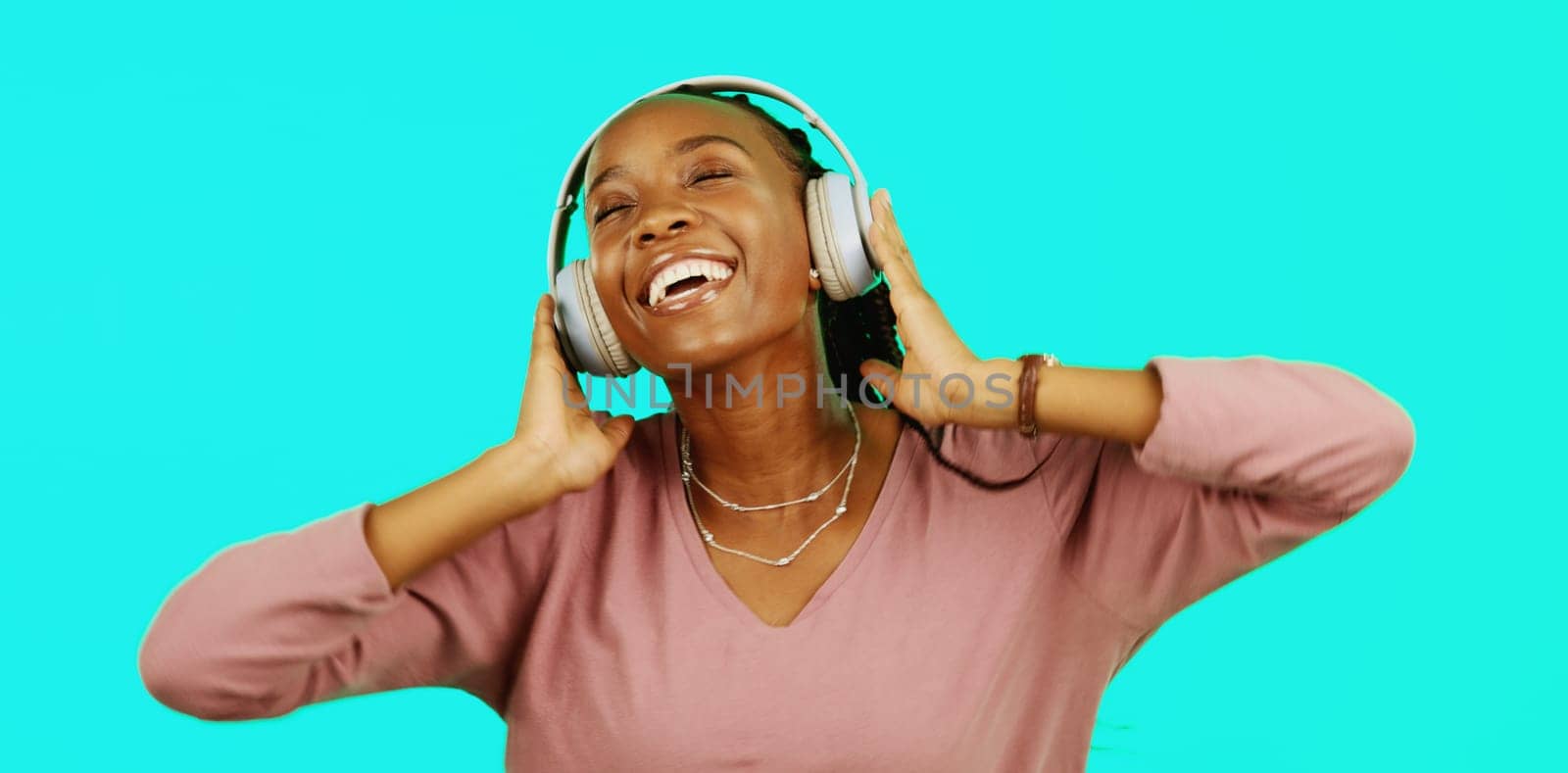 Dance, music and headphones with black woman in studio for freedom, streaming and online radio. Happiness, technology and relax with girl dancing to track, songs and audio isolated on background.