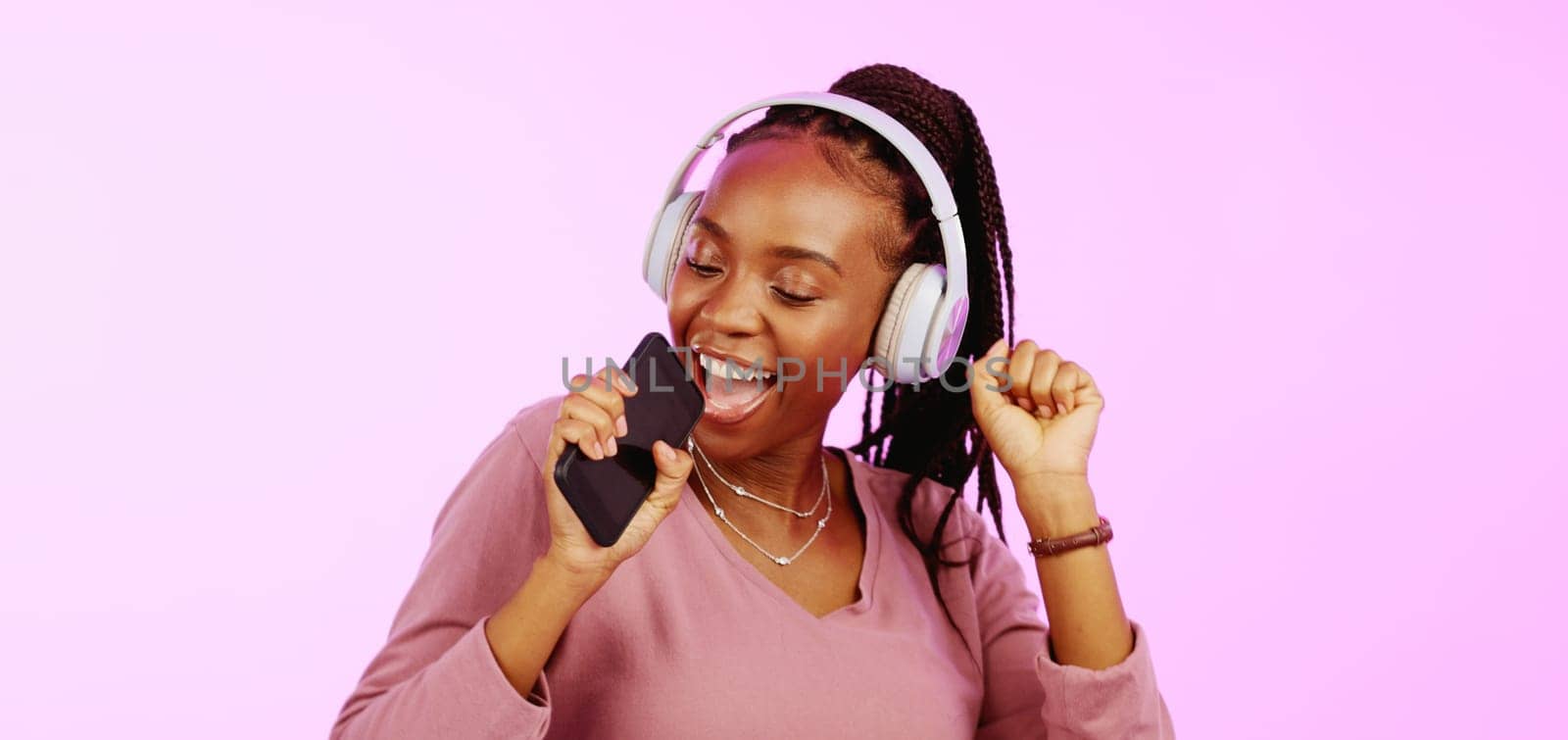 Sing, dance and black woman with headphones music microphone isolated on a studio background. Fun, happy and funky African girl listening to audio, radio or songs while singing and dancing on a backd.