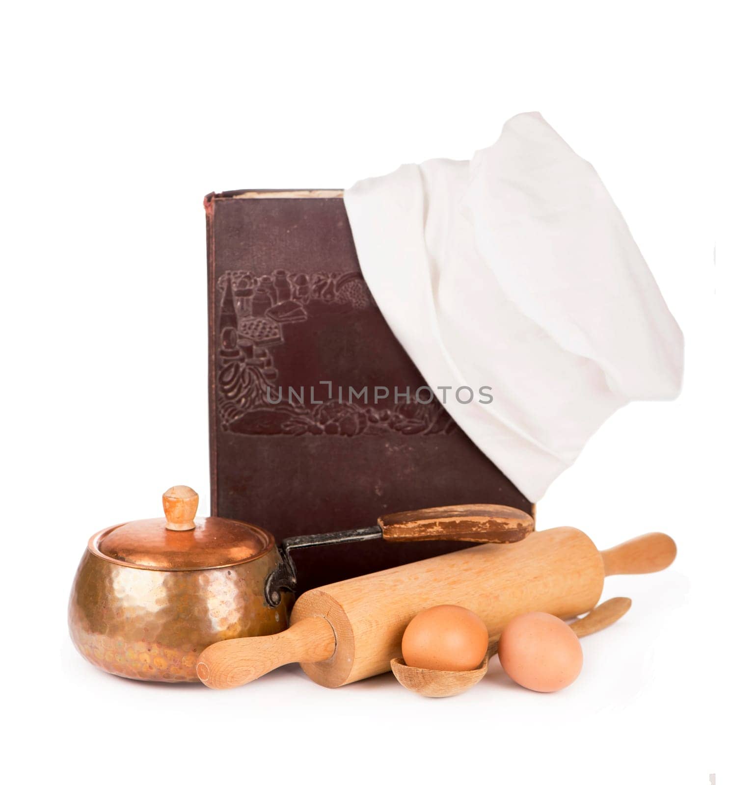 Chef's hat with battledore and cook book on white background