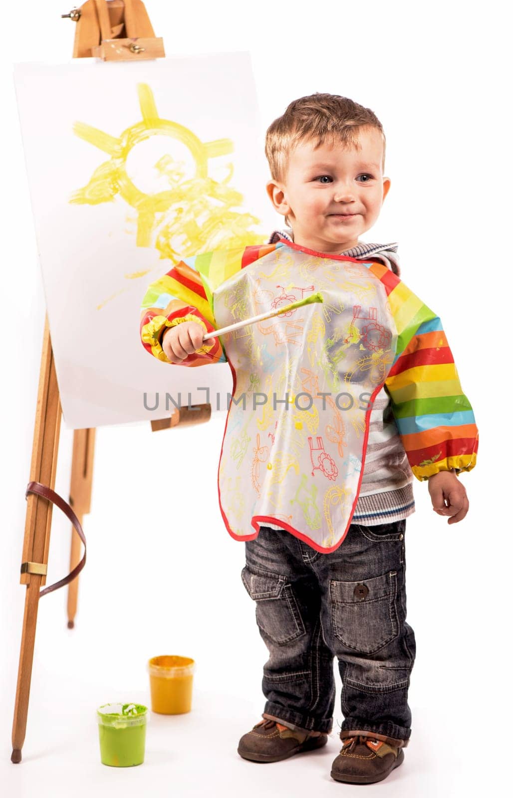 The small artist draws on a white background. The boy draws the sun with paints on a white sheet. by aprilphoto