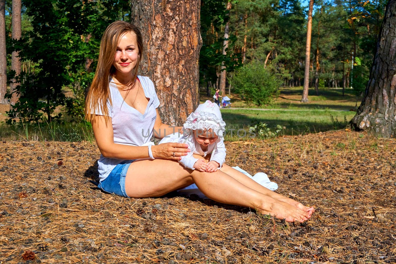 Young happy mother with a cute breast newborn baby in a sunny forest by jovani68