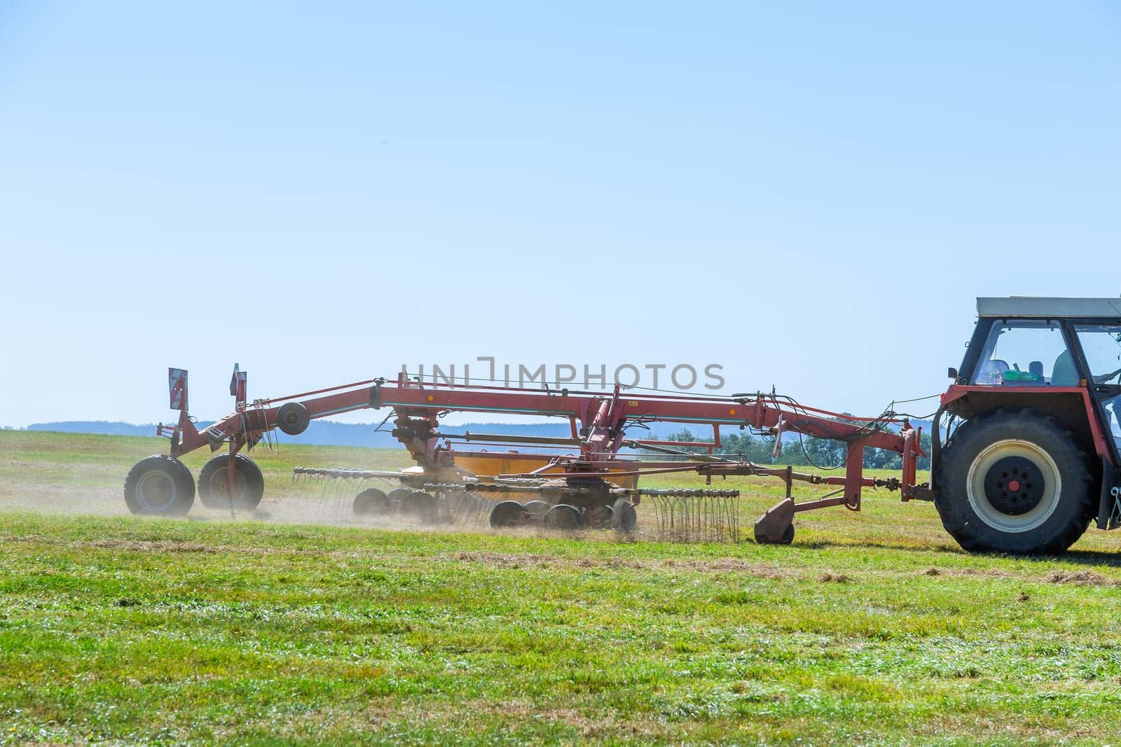 With help of tractor, farmer efficiently baled hay, ensuring good supply for year.