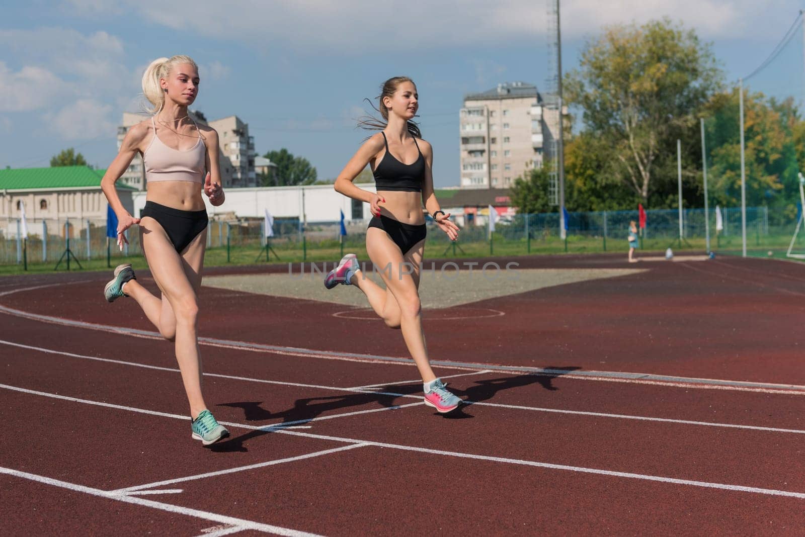 Two athlete young woman runnner on the start at the stadium outdoors