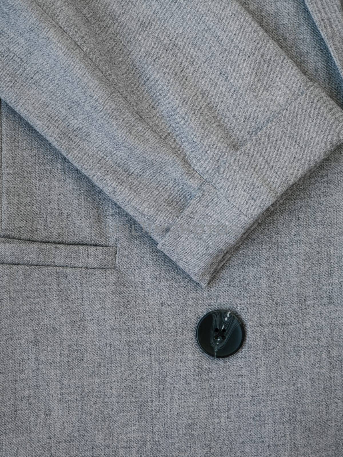 Texture of wool business jacket or coat. Grey women suit jacket with closeup buttons. Business or formal wear. Gray fabric for tailoring. The grey pinstripe suit cloth.