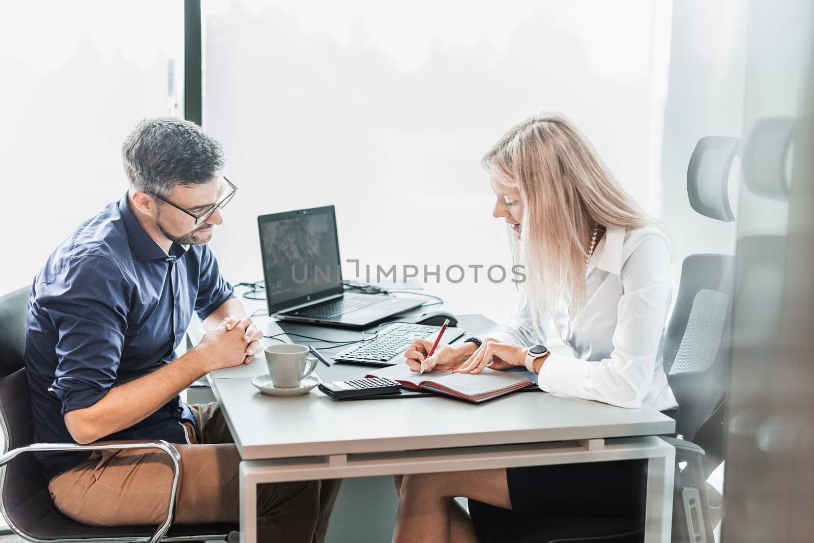 Business meeting. Client consulting. Confident business woman, real estate agent, financial advisor explaining details of project or financial product to client in office. by kasto