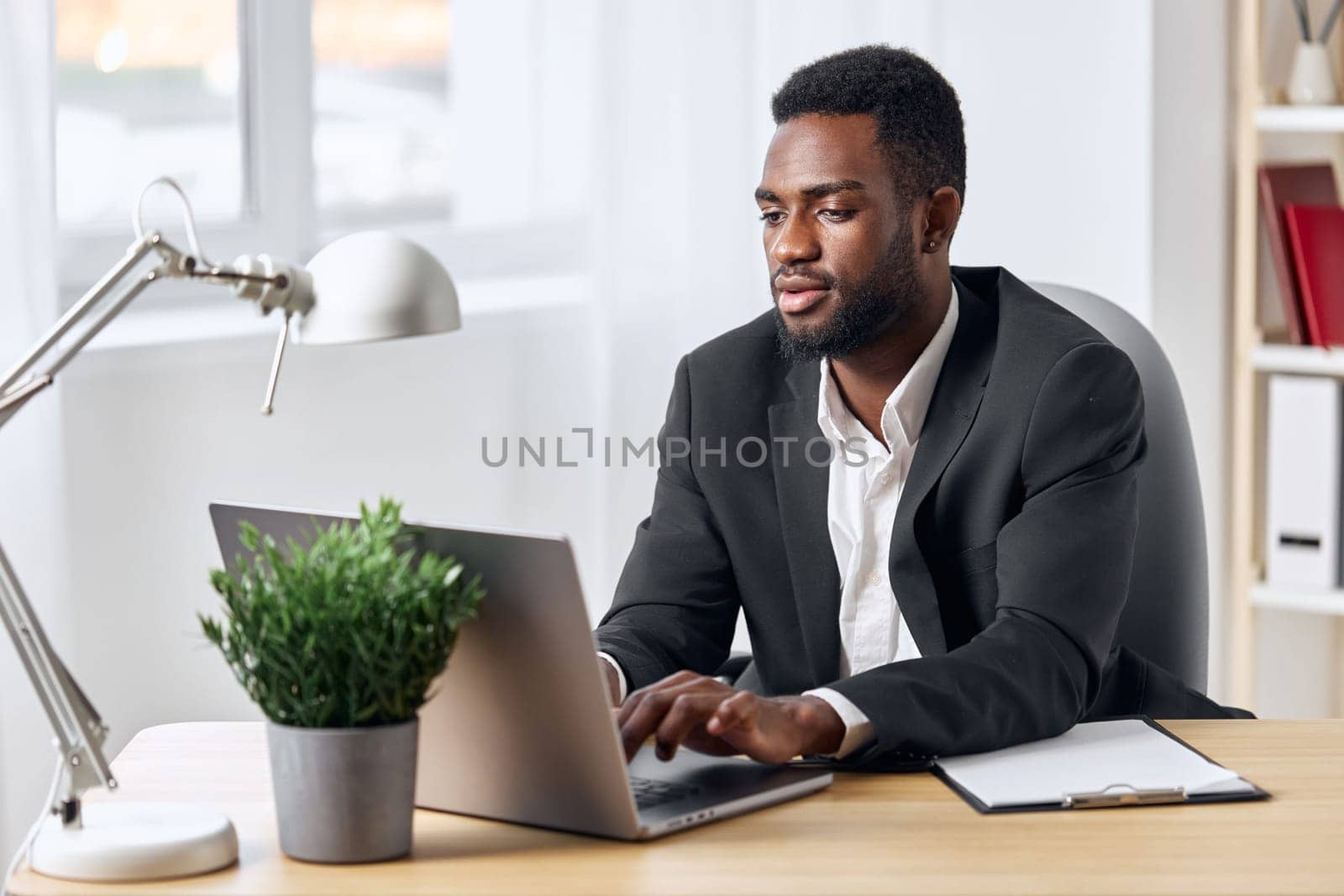 man employee office internet smiling sitting computer online african laptop table freelancer student work american job american black indoor business cyberspace education