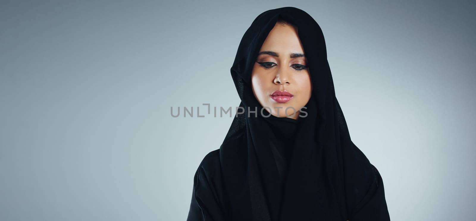 Shes got Islam in her heart. Studio shot of a young muslim businesswoman against a grey background. by YuriArcurs