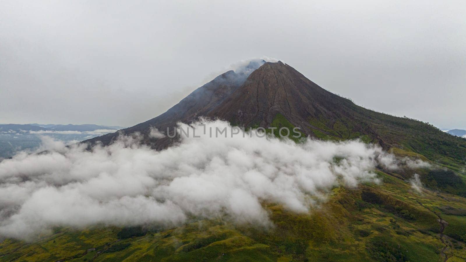 Active volcano Sinabung with clouds and smoke. Sumatra, Indonesia.