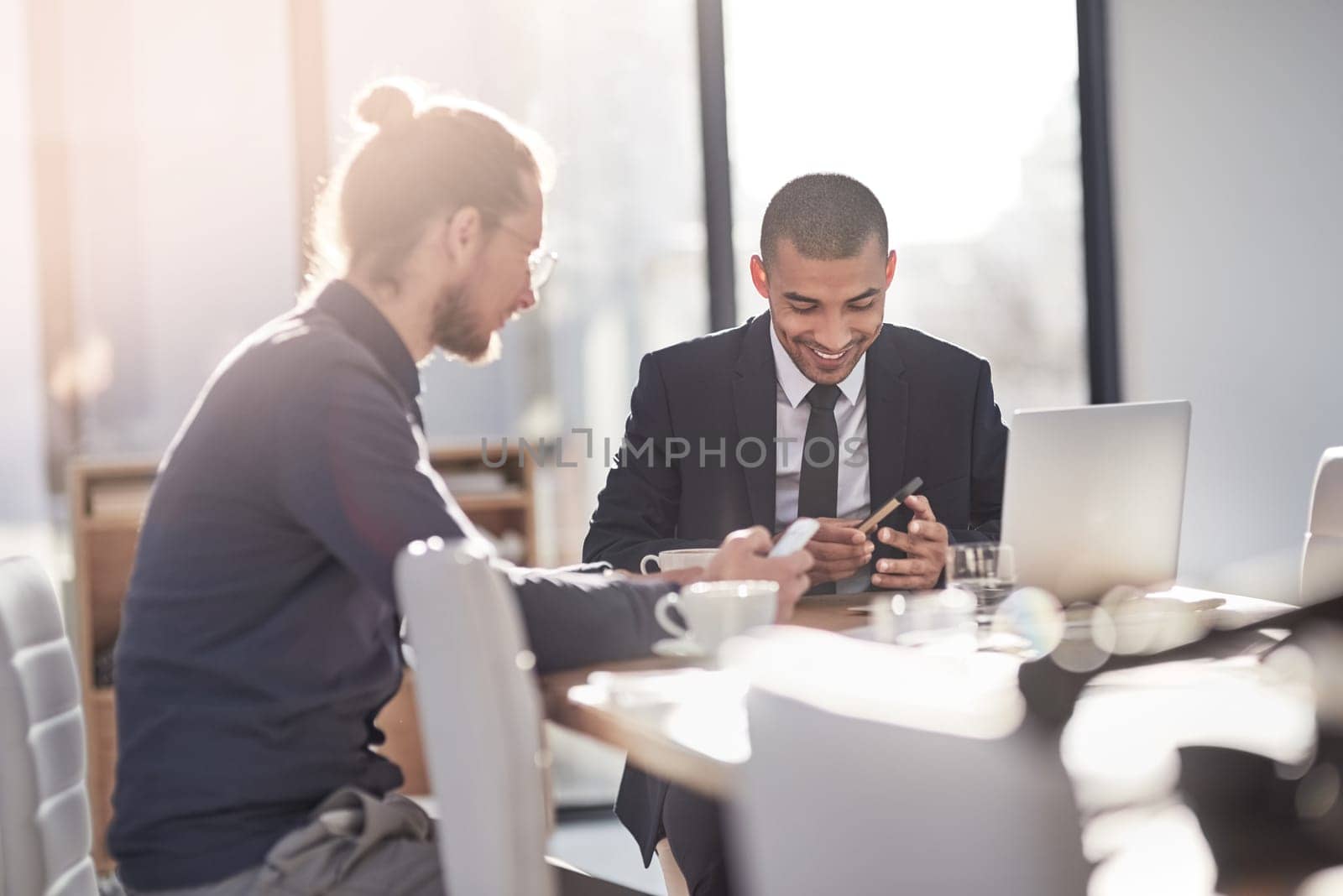 Smart technology simplifies the way they do business. two young businessmen using their smartphones at work