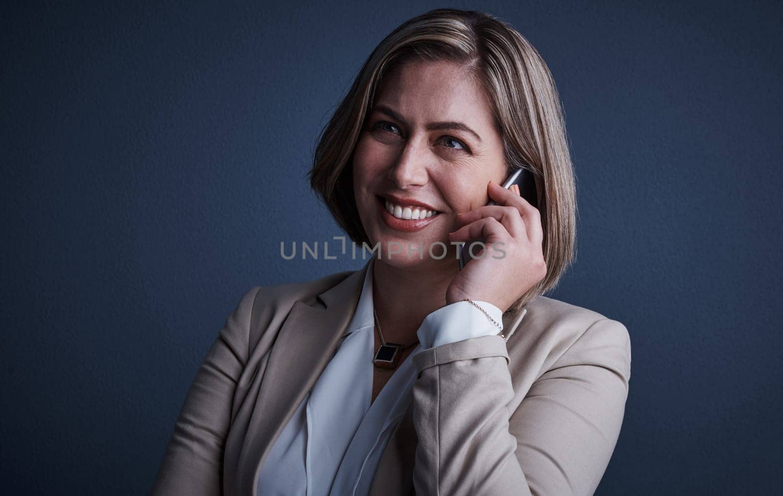 Communication is the key to success. Studio shot of an attractive young corporate businesswoman making a call against a dark background