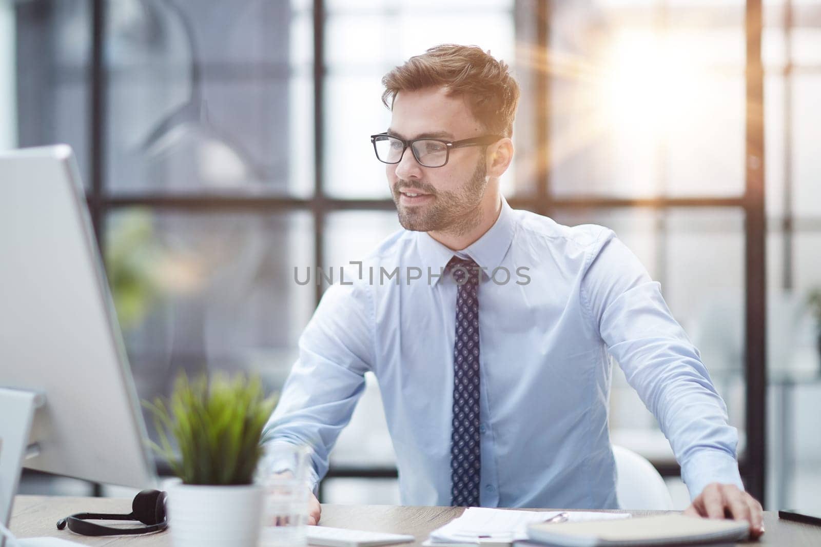 Young cheerful businessman working at office