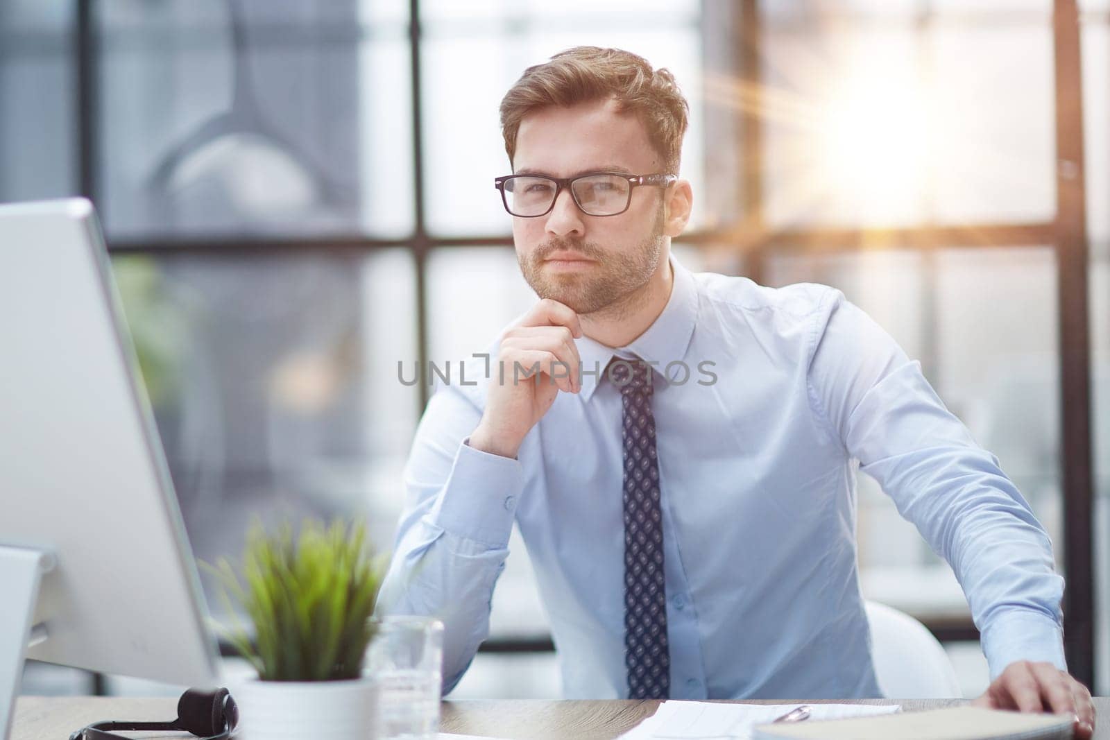 Young cheerful businessman working at office