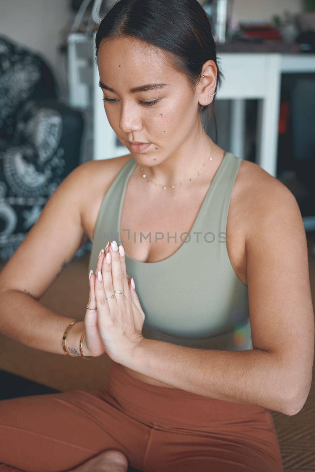 Yoga is one of the best solutions for stress relief. a young woman meditating while practising yoga at home. by YuriArcurs
