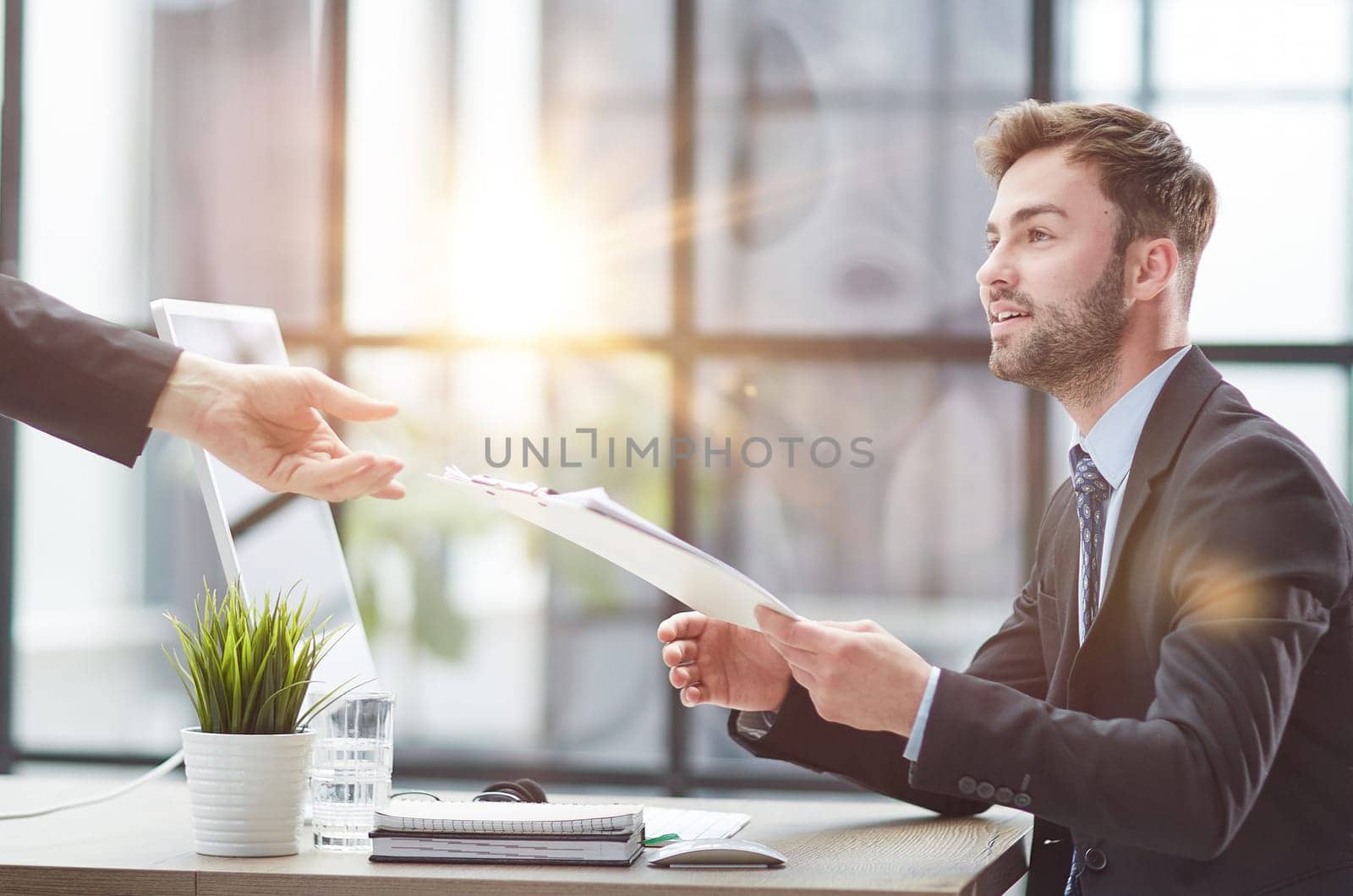 Businessman Taking Papers From Secretary In Office