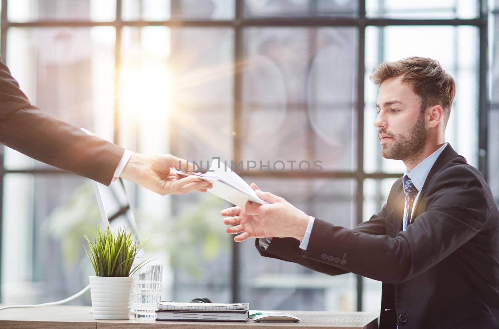 Businessman Taking Papers From Secretary In Office