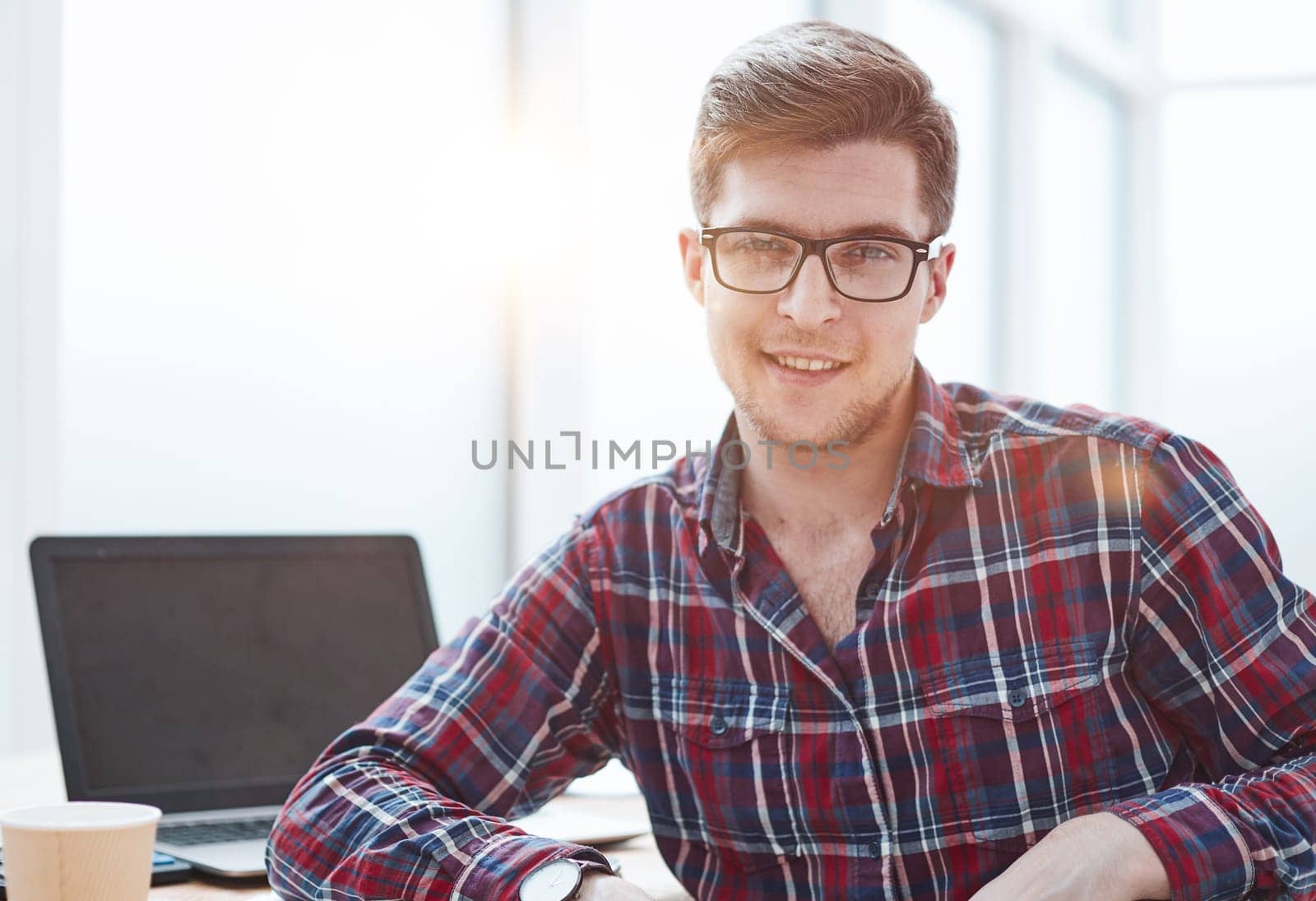 Young man with glasses working on his notebook, early in the morning, getting the business out of the way nice and early in the day