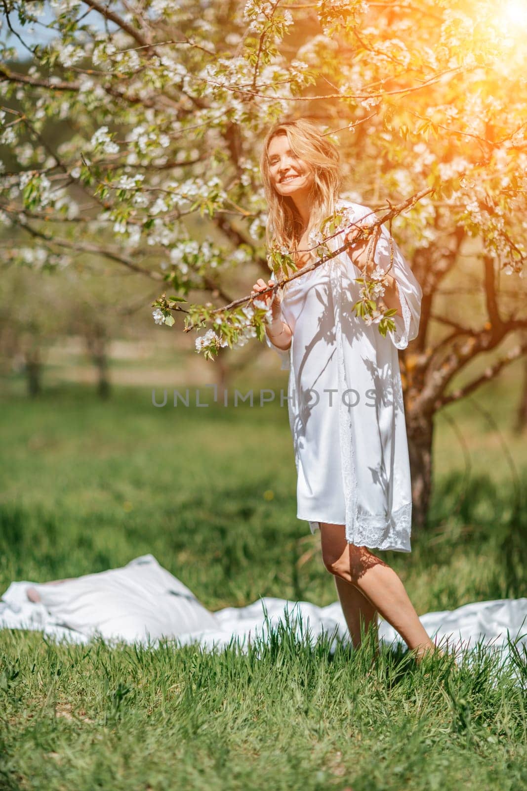 Portrait of a blonde in the park. Happy woman with long blond hair in a blue dress