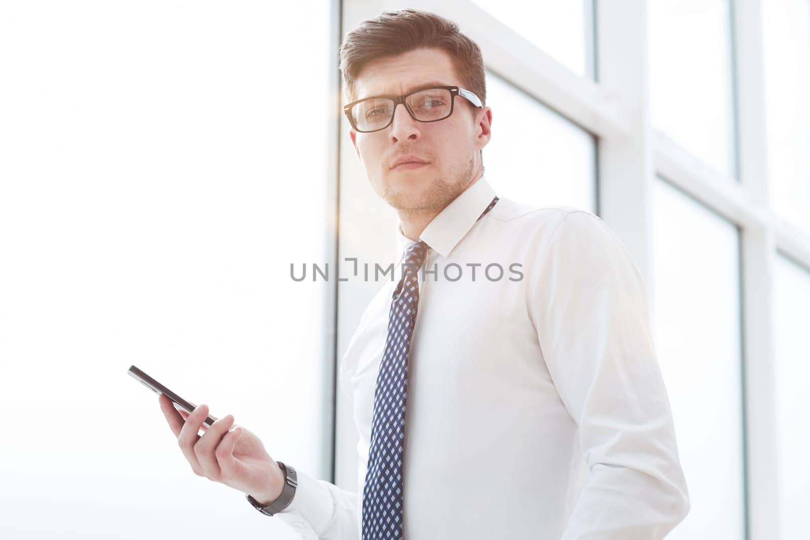 Businessman using smart phone in blurred office space background and copy space