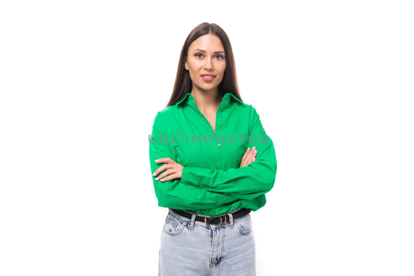 pretty young caucasian brunette lady with makeup dressed in a green shirt and jeans posing on a white background with copy space.