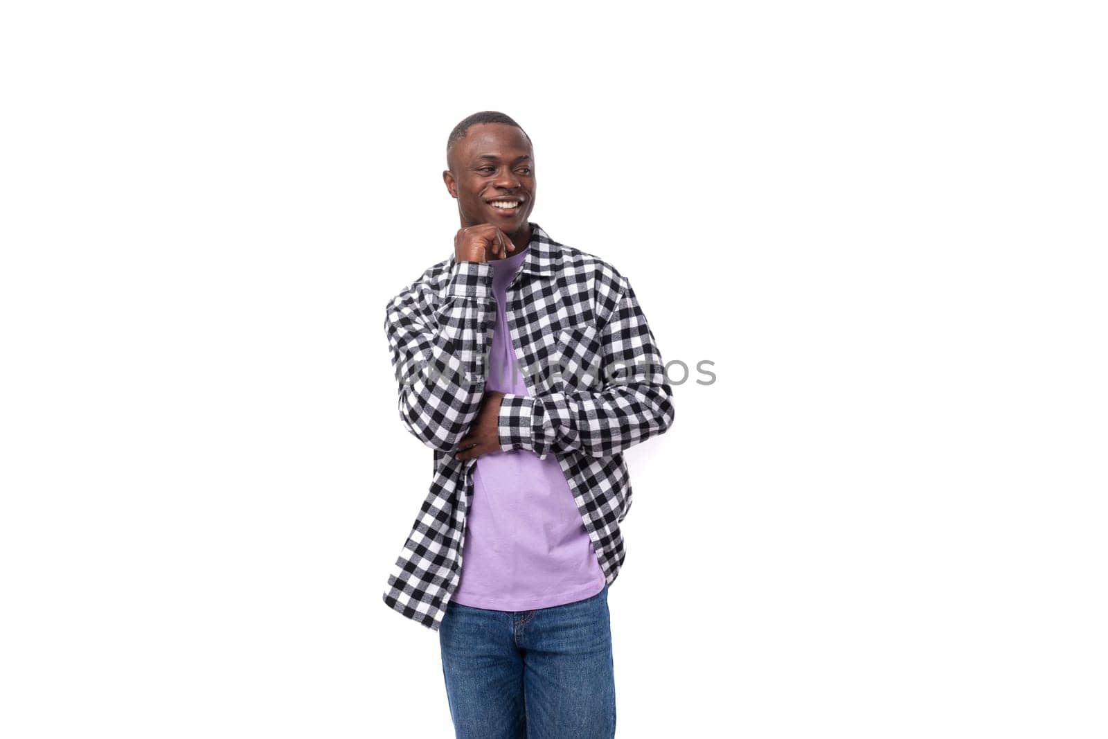 young man with dark skin in a plaid shirt and jeans on an isolated white background with copy space.