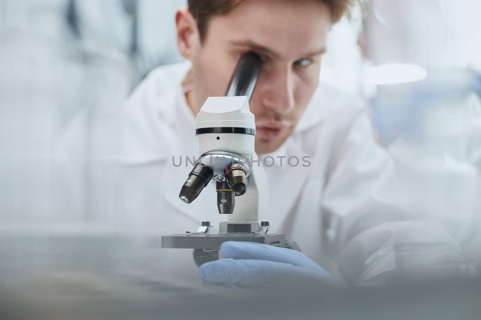 Scientist looks through a microscope in a laboratory. research concept