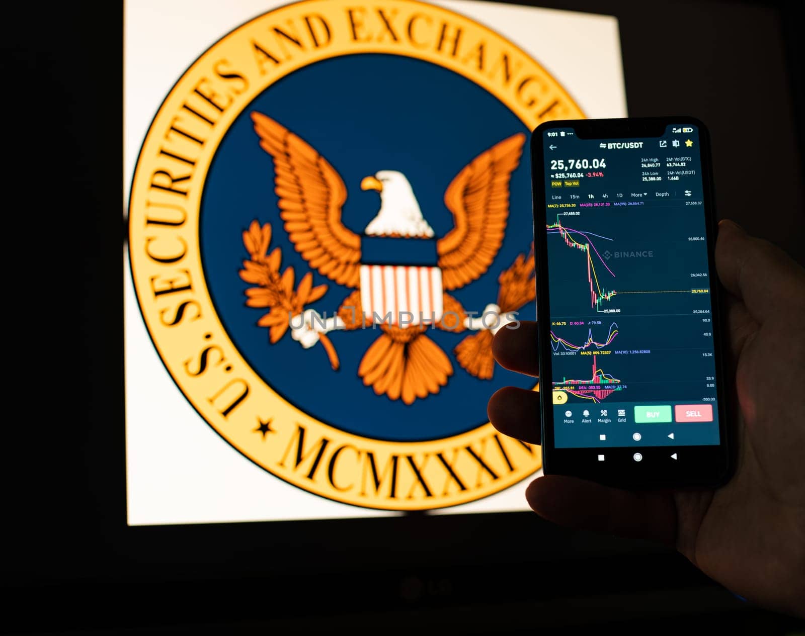 Kyiv, Ukraine - 06 June 2023: Man holds a smartphone with falling Bitcoin chart on Binance against the background the SEC logo. S.E.C. Accuses Binance of Mishandling Funds and Lying to Regulators