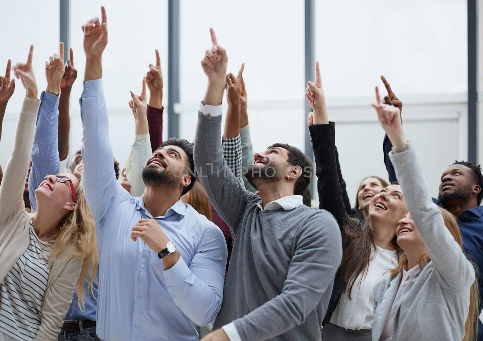 happy group of diverse young people holding their hands up by Prosto