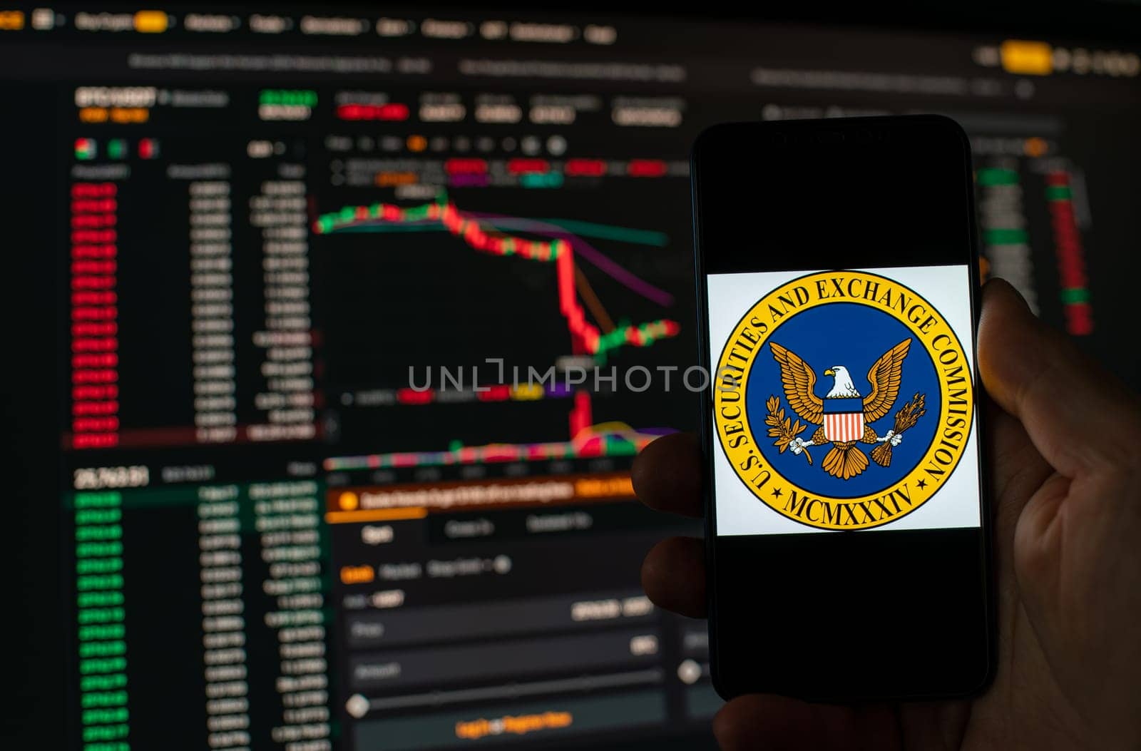 Kyiv, Ukraine - 06 June 2023: Man holds a smartphone with SEC logo against the background falling Bitcoin chart on Binance - crash. S.E.C. Accuses Binance of Mishandling Funds and Lying to Regulators