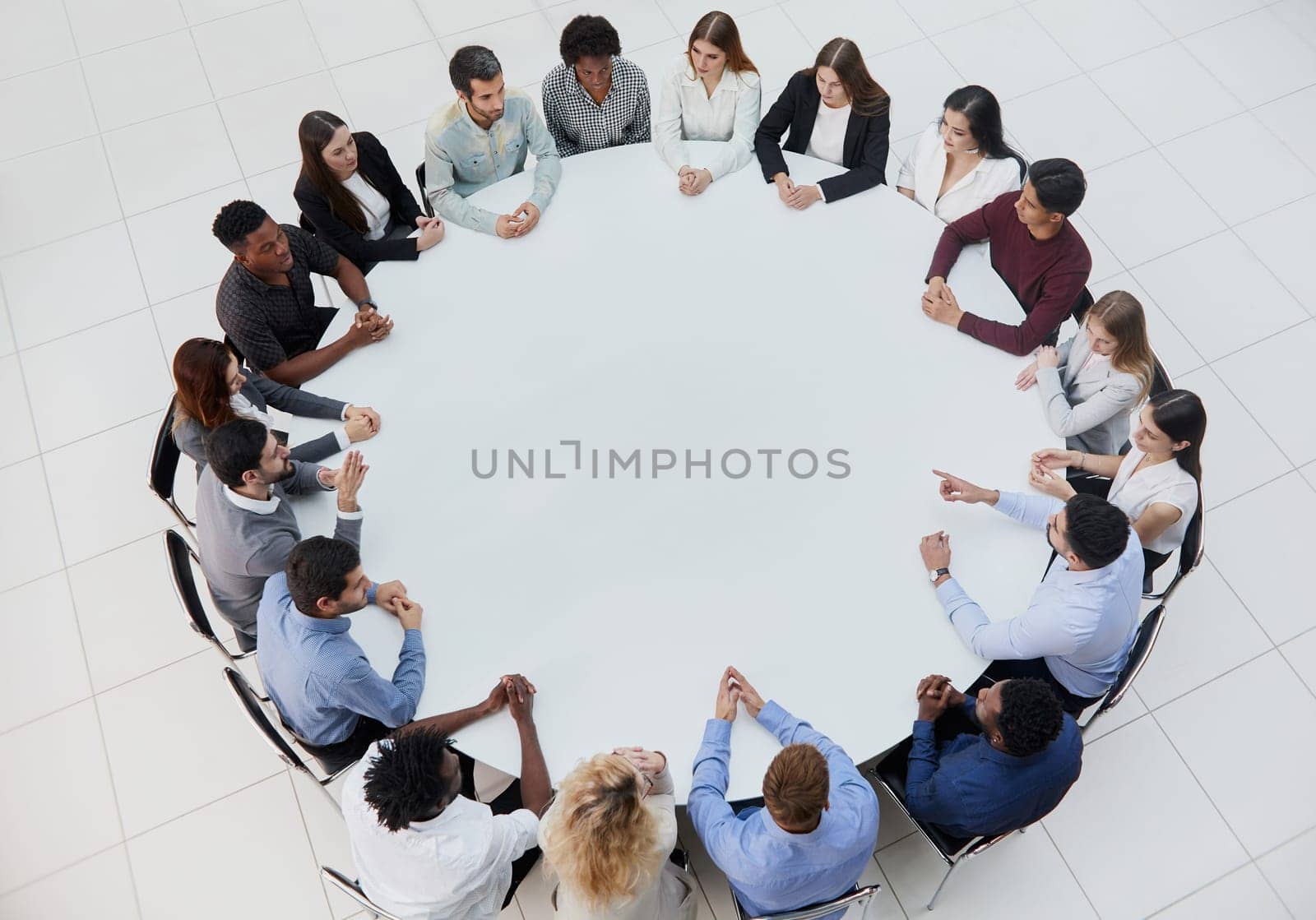 Businessmen or office workers are sitting at a round table in casual clothes.