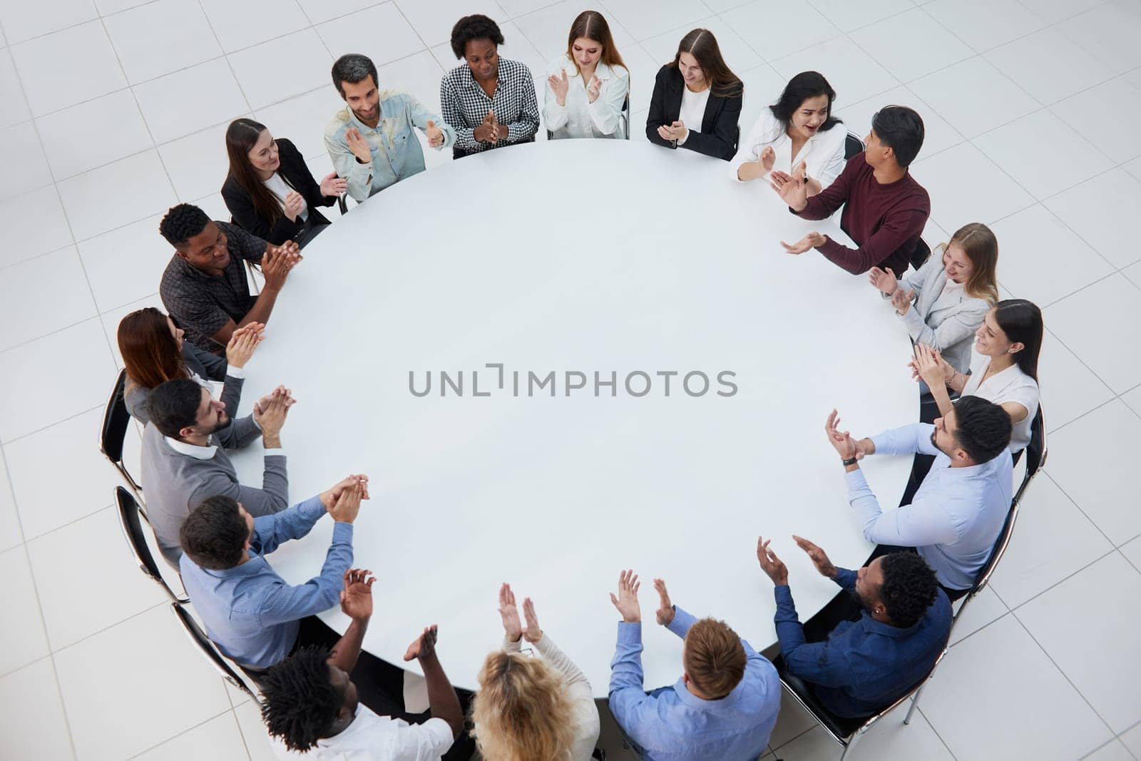 Businessmen or office workers are sitting at a round table in casual clothes.