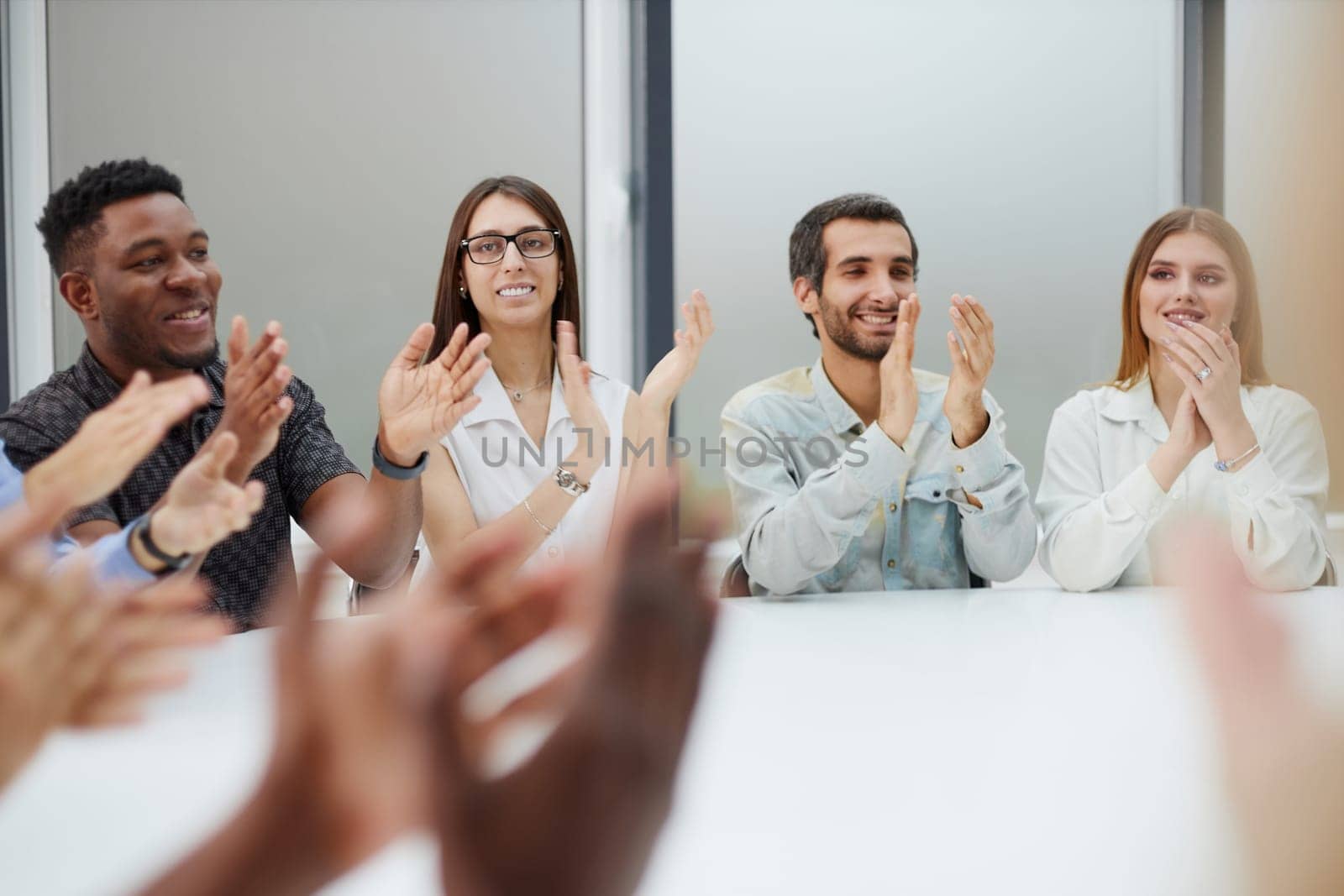 Group of young business workers smiling and clapping to partner at the office