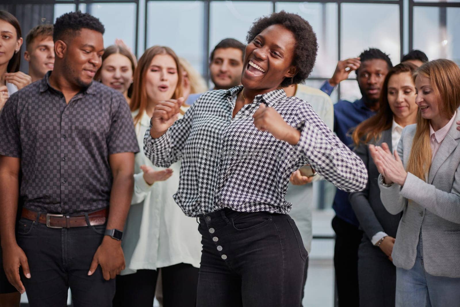 Smiling multiethnic colleagues celebrating common business success or victory in the office.