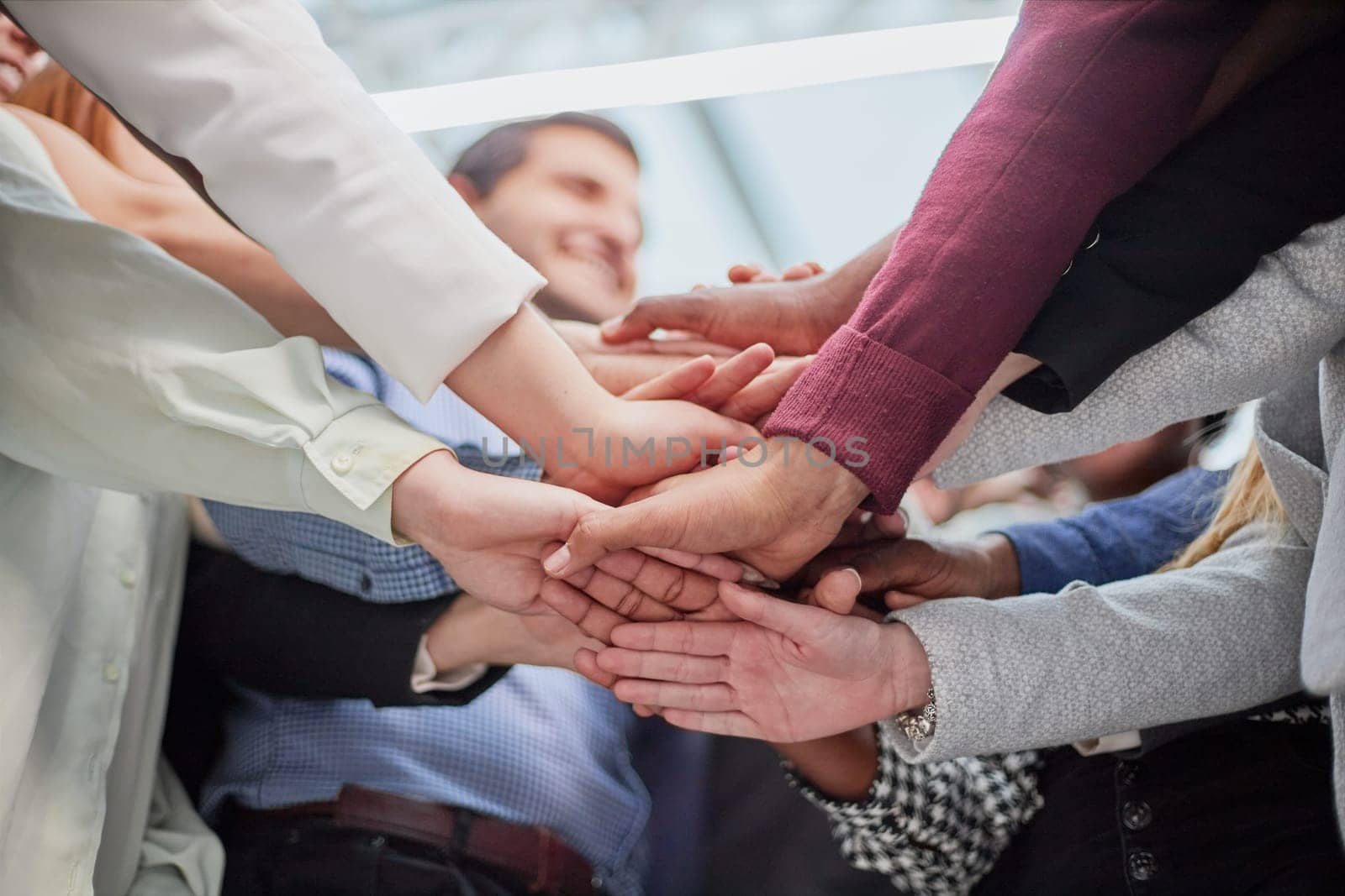 Young happy people stacking hands. Diverse culture students celebrating together - Focus on hands