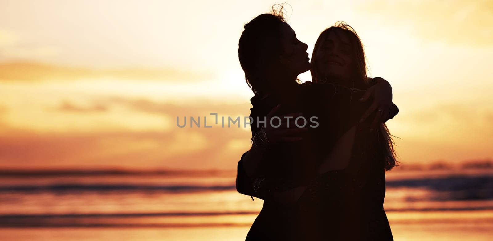 Spread love wherever you go. two young women spending the day at the beach at sunset. by YuriArcurs