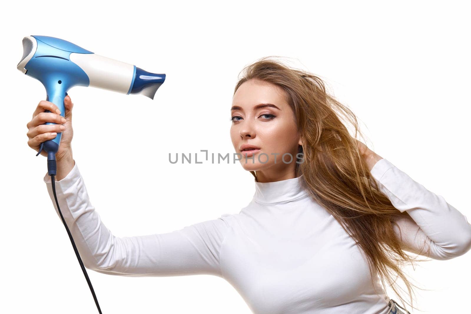 Portrait of attractive cheerful girl drying long hair isolated on white background