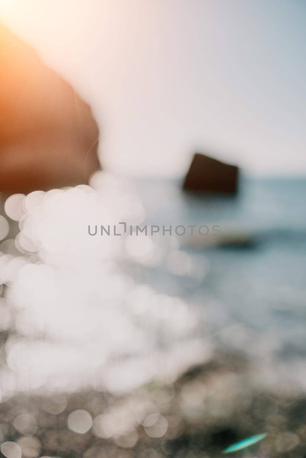 Abstract sea summer ocean sunset nature background. Small waves on golden water surface in motion blur with golden bokeh lights from sun. Holiday, vacation and recreational concept.