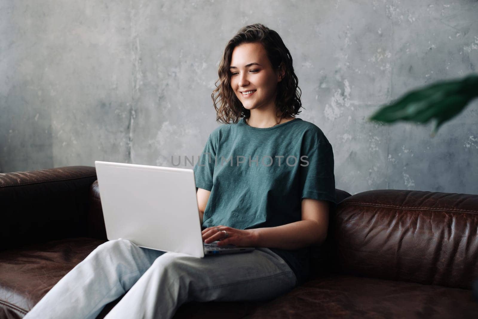 Productivity and Independence: Young Woman Engages in Remote Work and Study, Utilizing Laptop in the Comfort of Home. Embracing the Benefits of Freelancing, Business Ventures, and a Flexible Lifestyle