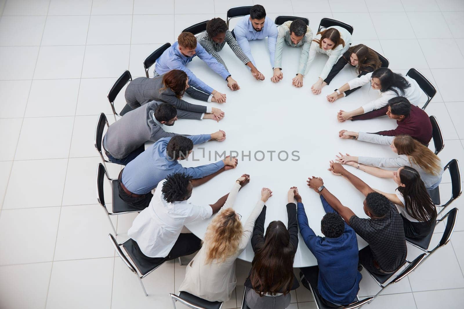 Businessmen and women in meeting at large round table, elevated view