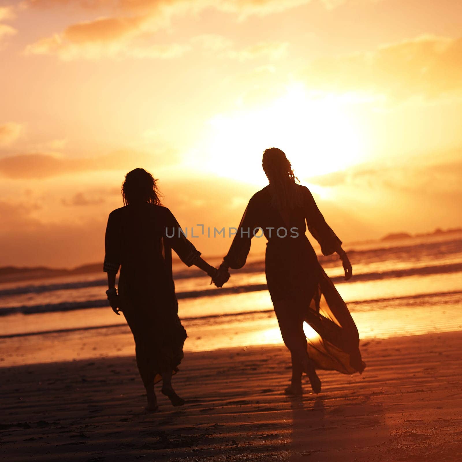 Surround yourself with those who light your path. two young women spending the day at the beach at sunset. by YuriArcurs