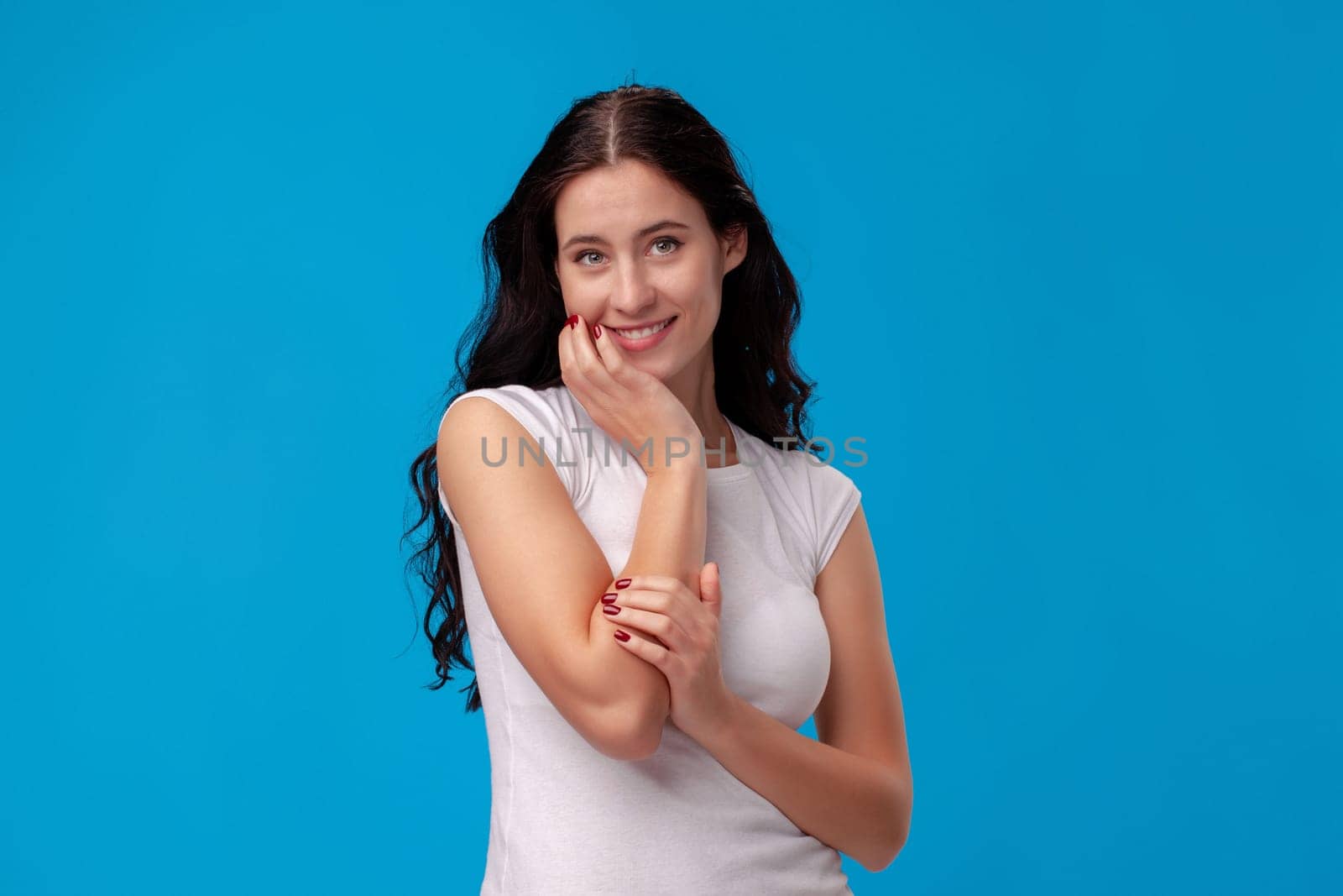 Smiling attractive young woman thinking on the blue background