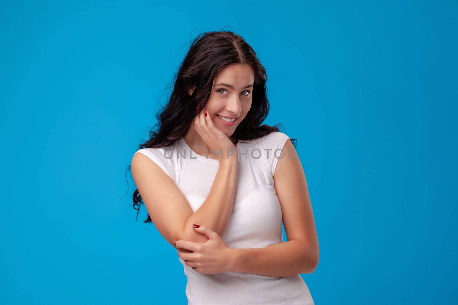 Smiling attractive young woman thinking on the blue background