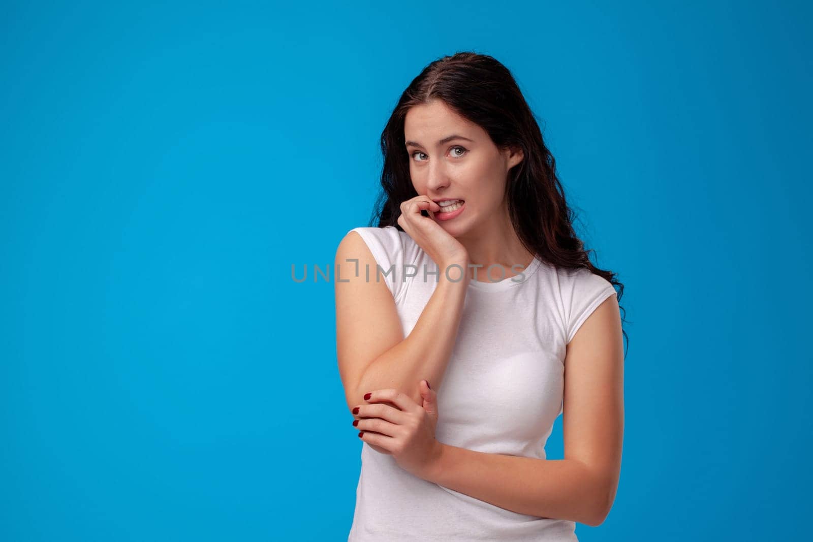 Thoughtful attractive young woman thinking on the blue background