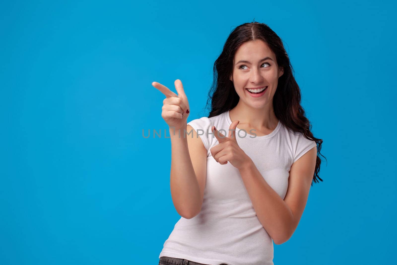 Woman making gun gesture on the blue background