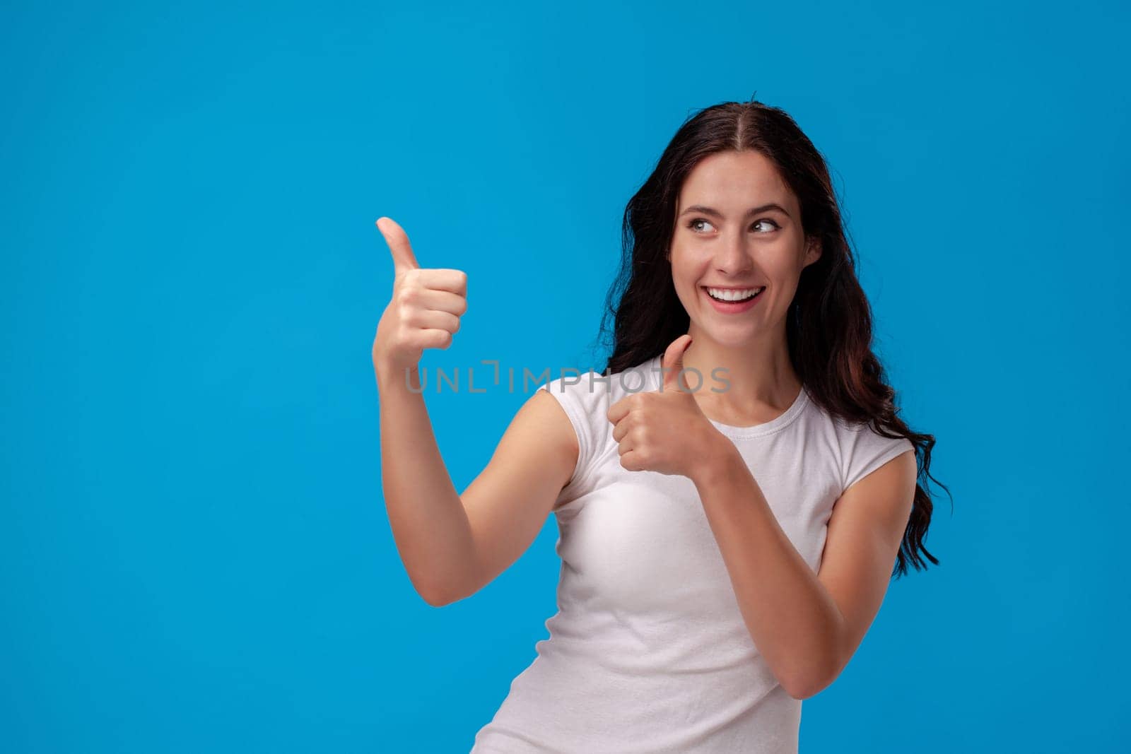 Smiling woman giving thumbs up on the blue background