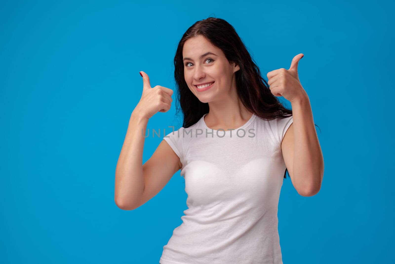 Smiling woman giving thumbs up on the blue background