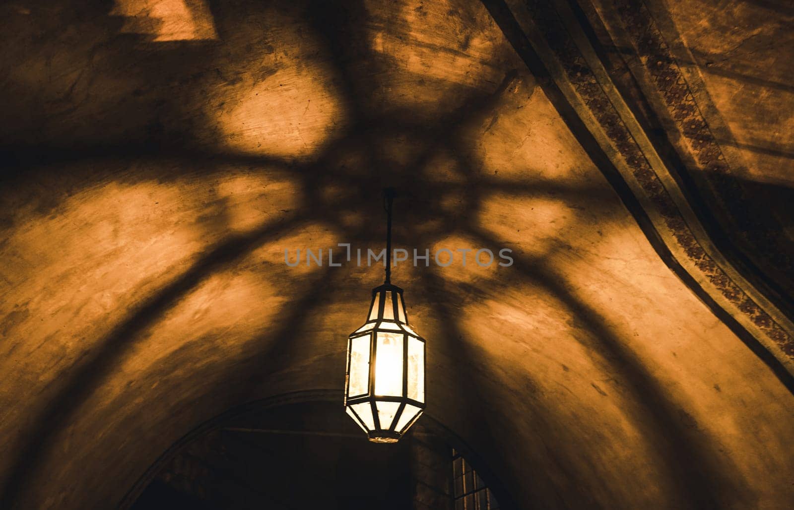 light from the lamp on the ceiling and the shadows in the mysterious arch