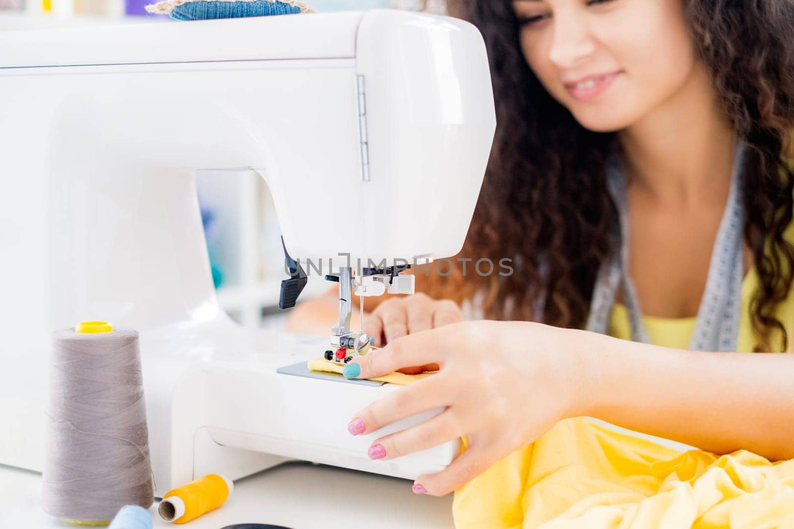 Close up view of female hands working on sewing machine